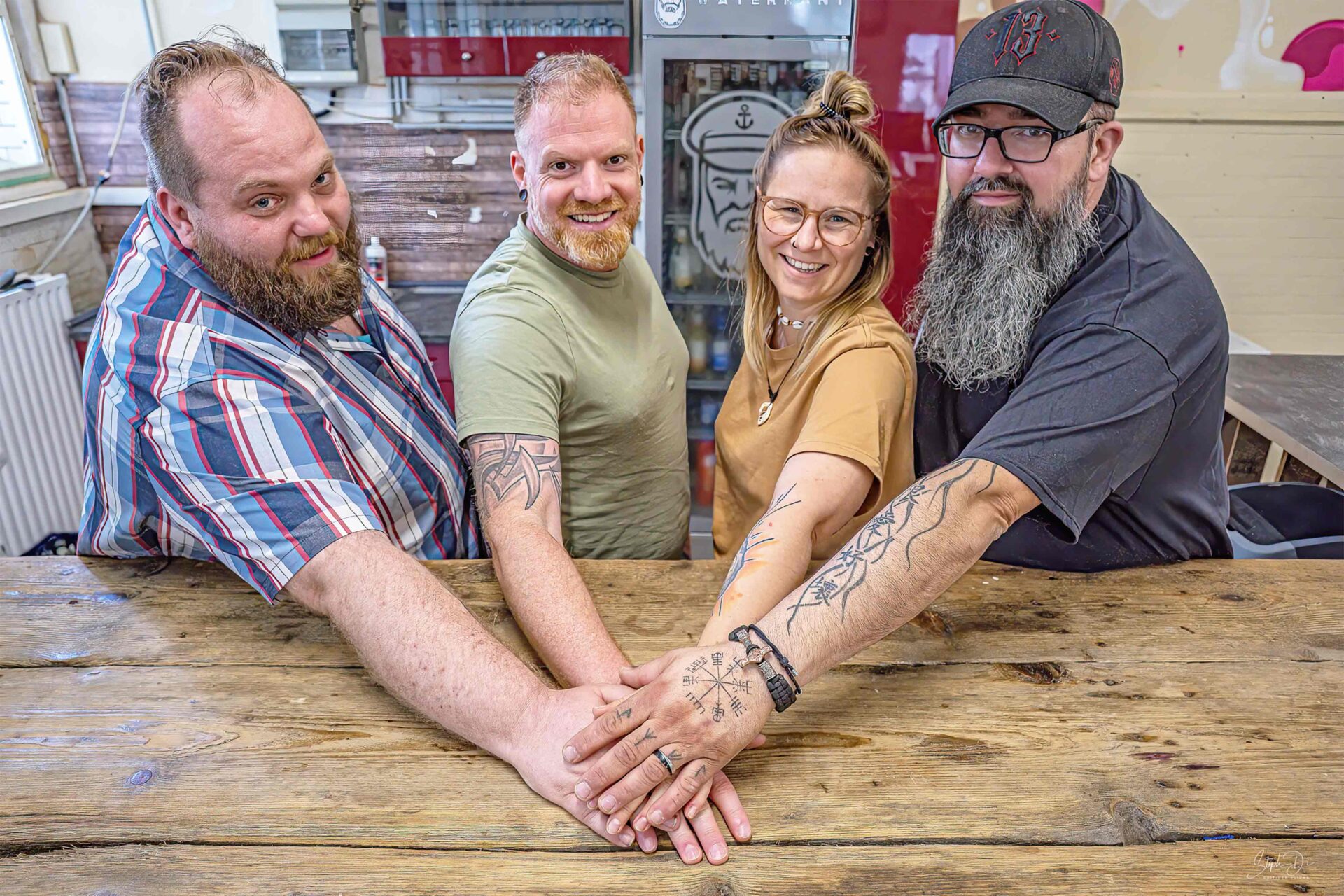 Teamwork und Gruppenfoto vom Alsenhof. Jan, Heiko, Anne und Daniel gestalten gemeinsam den Alsenhof. Hände zusammen. Gemeinsam stark